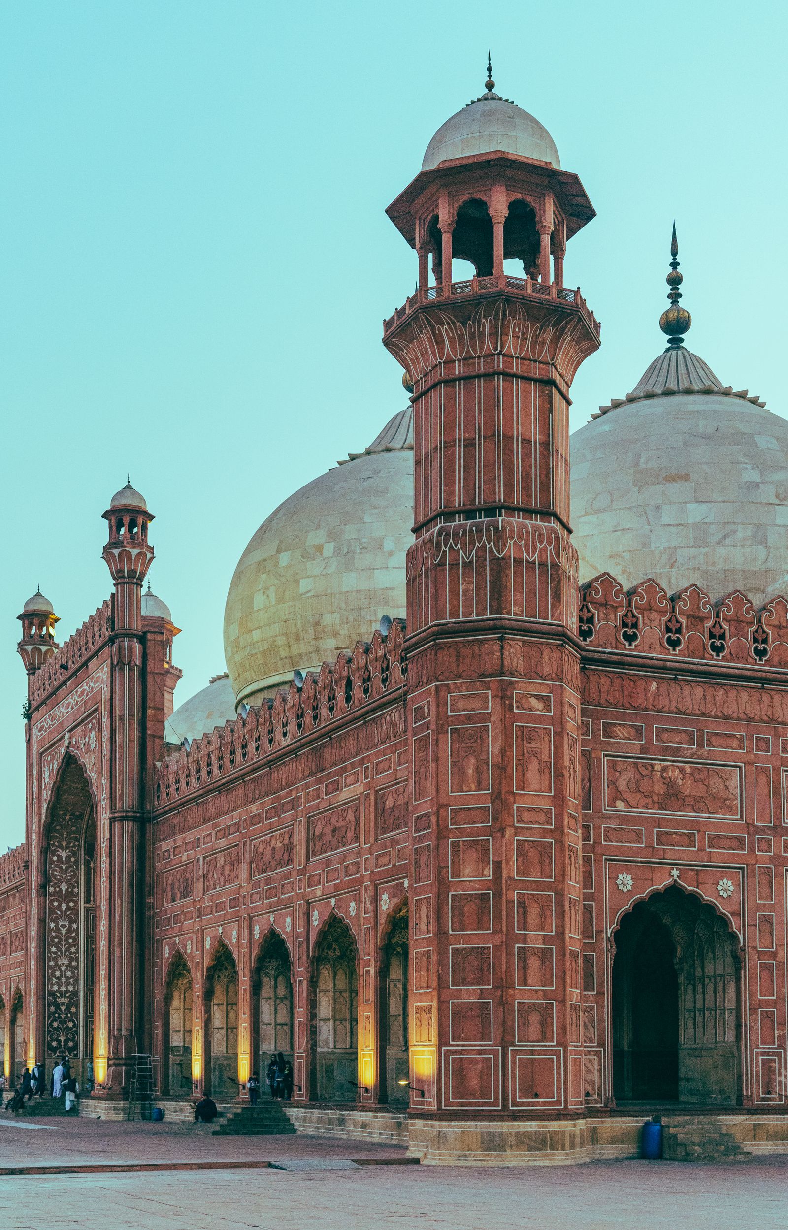 Badshahi Mosque in Lahore glowing at dusk under a cloudy sky